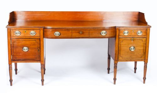 fig 1. A late 18th-century George III mahogany sideboard featuring a raised gallery back, string inlay, central drawer flanked by cupboards, brass ring handles, and turned legs.