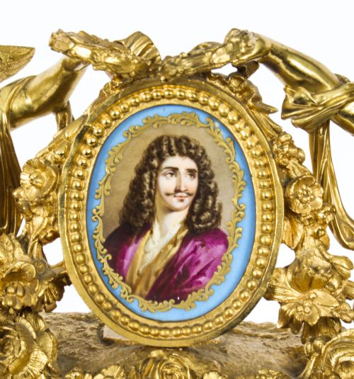 fig 4. An 19th-century French gilt bronze mantel clock with two winged cherubs flanking an oval portrait plaque of Moliere above a porcelain dial.
