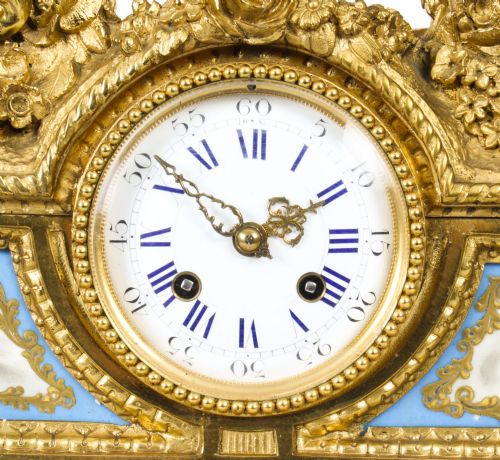 fig 5. An 19th-century French gilt bronze mantel clock with two winged cherubs flanking an oval portrait plaque of Moliere above a porcelain dial.