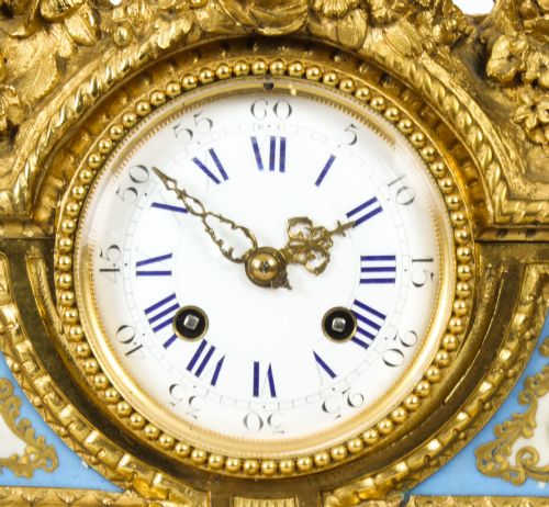 fig 6. An 19th-century French gilt bronze mantel clock with two winged cherubs flanking an oval portrait plaque of Moliere above a porcelain dial.