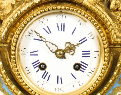 fig 7. An 19th-century French gilt bronze mantel clock with two winged cherubs flanking an oval portrait plaque of Moliere above a porcelain dial.