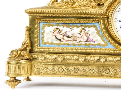 fig 8. An 19th-century French gilt bronze mantel clock with two winged cherubs flanking an oval portrait plaque of Moliere above a porcelain dial.