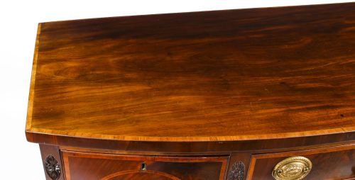 fig 2. An 18th-century George III flame mahogany sideboard featuring circular inlaid panels, brass ring handles, and square tapered legs.