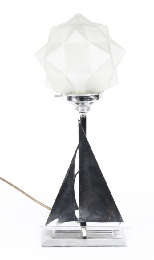 fig 1. An Art Deco chrome table lamp featuring a stylized sailboat stem set upon a stepped rectangular base, topped with a faceted frosted glass shade.