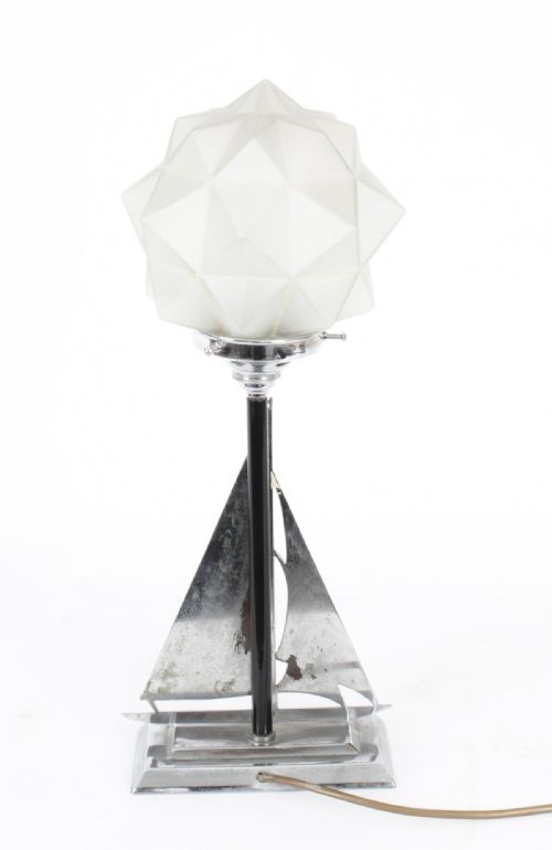 fig 2. An Art Deco chrome table lamp featuring a stylized sailboat stem set upon a stepped rectangular base, topped with a faceted frosted glass shade.