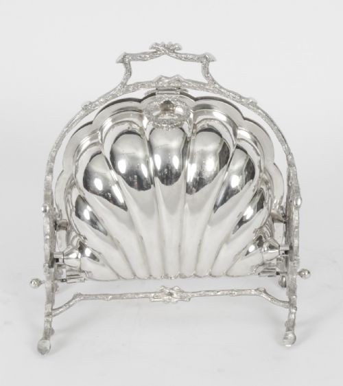 fig 1. A Victorian silver-plated folding biscuit box in the shape of a clam shell, supported by a cast branch-like metal frame.