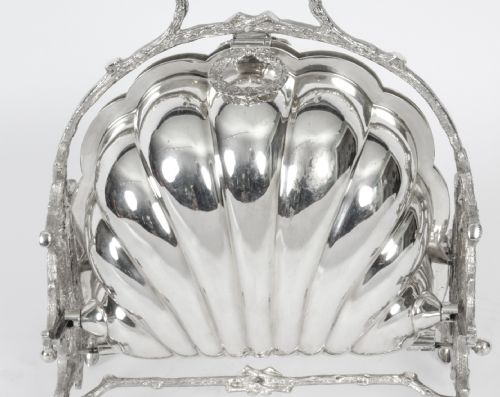 fig 2. A Victorian silver-plated folding biscuit box in the shape of a clam shell, supported by a cast branch-like metal frame.