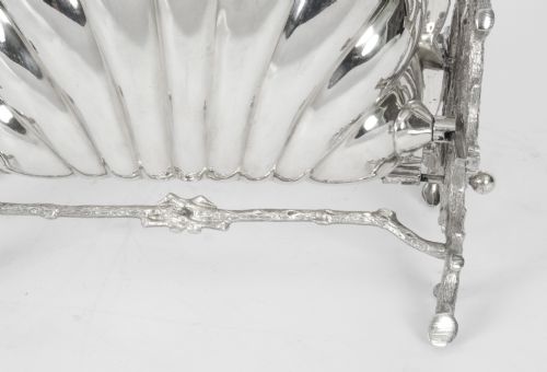 fig 3. A Victorian silver-plated folding biscuit box in the shape of a clam shell, supported by a cast branch-like metal frame.