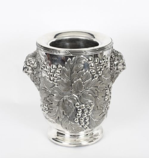 fig 1. A pair of nineteenth-century silver-plated wine coolers featuring relief grapevines and side handles on pedestal bases.