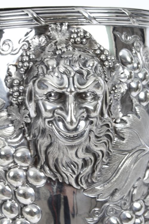 fig 3. A pair of nineteenth-century silver-plated wine coolers featuring relief grapevines and side handles on pedestal bases.
