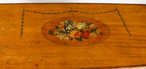 fig 6. A pair of 19th-century Adam Revival painted satinwood side cabinets featuring painted oval musical medallions, draped garlands, single top drawers, double cupboards, and turned tapered legs.