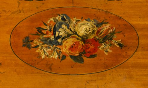 fig 7. A pair of 19th-century Adam Revival painted satinwood side cabinets featuring painted oval musical medallions, draped garlands, single top drawers, double cupboards, and turned tapered legs.