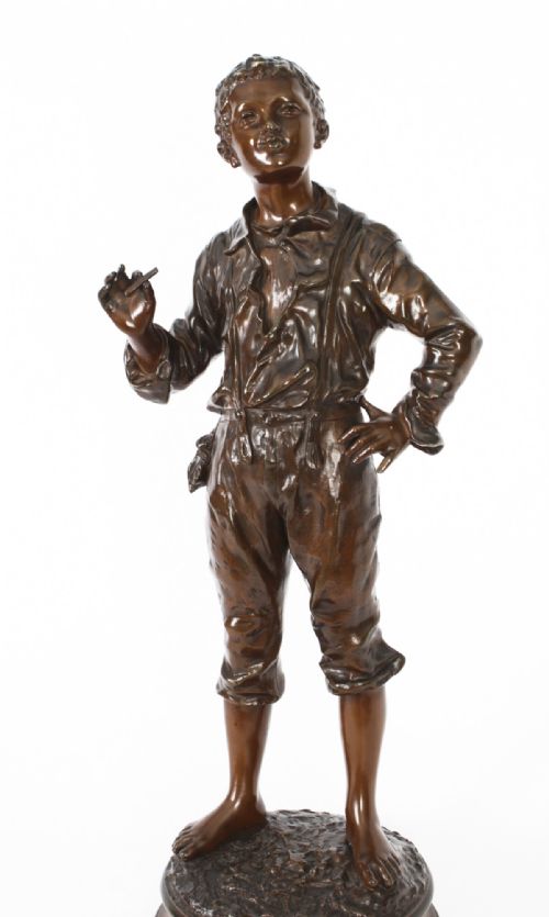 fig 1. A 19th-century French bronze sculpture depicting a standing young boy in working clothing on a circular base.