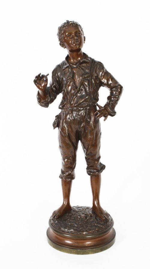 fig 2. A 19th-century French bronze sculpture depicting a standing young boy in working clothing on a circular base.