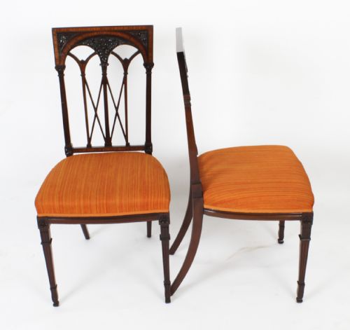 fig 1. A pair of antique Sheraton Revival mahogany side chairs featuring carved arched back tracery, turned front legs, and orange striped fabric seats.