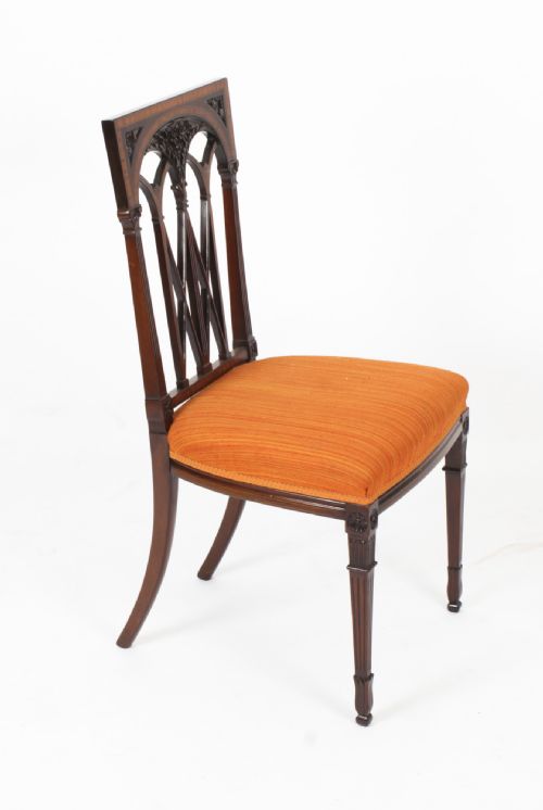 fig 2. A pair of antique Sheraton Revival mahogany side chairs featuring carved arched back tracery, turned front legs, and orange striped fabric seats.