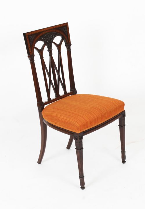 fig 3. A pair of antique Sheraton Revival mahogany side chairs featuring carved arched back tracery, turned front legs, and orange striped fabric seats.