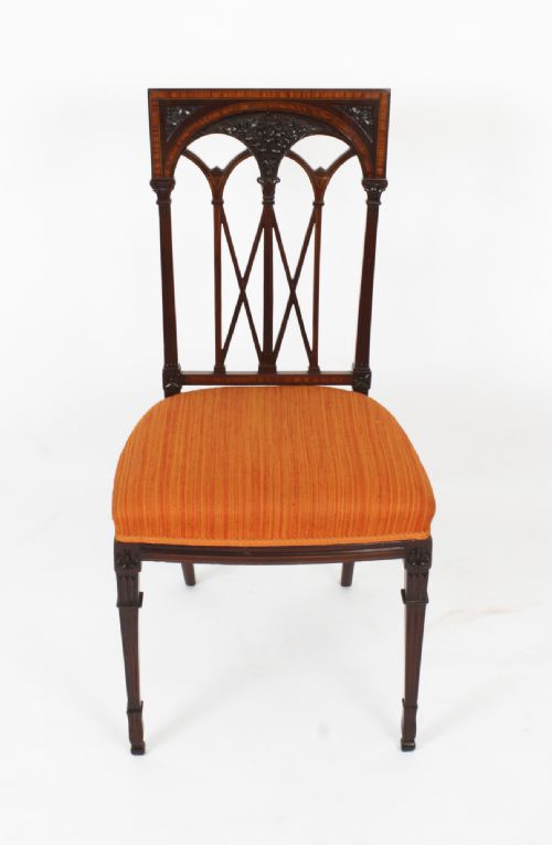 fig 4. A pair of antique Sheraton Revival mahogany side chairs featuring carved arched back tracery, turned front legs, and orange striped fabric seats.