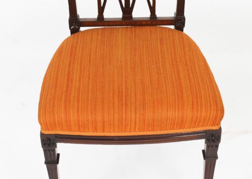 fig 6. A pair of antique Sheraton Revival mahogany side chairs featuring carved arched back tracery, turned front legs, and orange striped fabric seats.