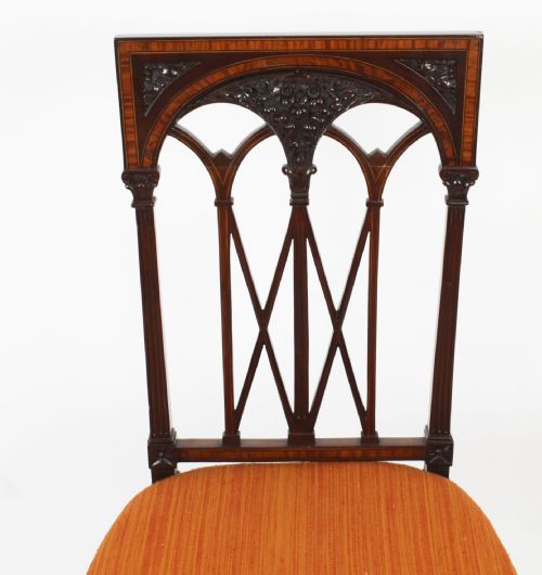 fig 7. A pair of antique Sheraton Revival mahogany side chairs featuring carved arched back tracery, turned front legs, and orange striped fabric seats.