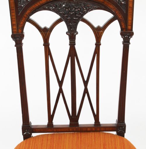 fig 8. A pair of antique Sheraton Revival mahogany side chairs featuring carved arched back tracery, turned front legs, and orange striped fabric seats.