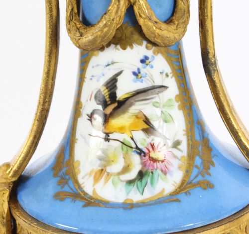 fig 3. A pair of 19th-century French Sevres-style bleu celeste porcelain urns featuring hand-painted floral and bird reserves, supported by gilt metal mounts and pedestals.