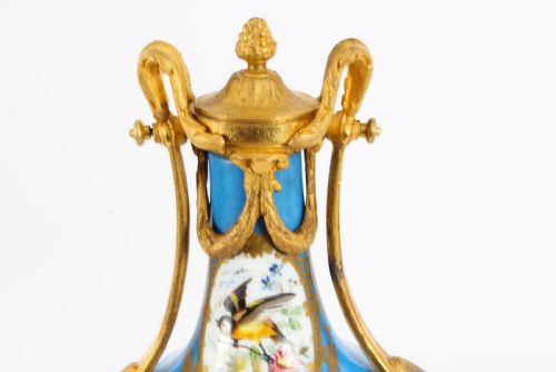 fig 4. A pair of 19th-century French Sevres-style bleu celeste porcelain urns featuring hand-painted floral and bird reserves, supported by gilt metal mounts and pedestals.