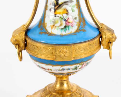 fig 5. A pair of 19th-century French Sevres-style bleu celeste porcelain urns featuring hand-painted floral and bird reserves, supported by gilt metal mounts and pedestals.