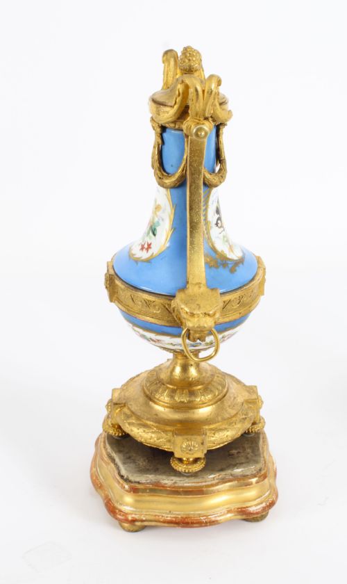 fig 7. A pair of 19th-century French Sevres-style bleu celeste porcelain urns featuring hand-painted floral and bird reserves, supported by gilt metal mounts and pedestals.