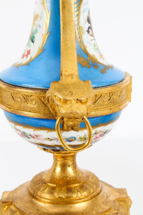 fig 8. A pair of 19th-century French Sevres-style bleu celeste porcelain urns featuring hand-painted floral and bird reserves, supported by gilt metal mounts and pedestals.