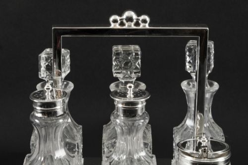 fig 2. A Victorian silver-plated rectangular cruet stand holding six faceted cut-glass condiment bottles with metal tops and glass stoppers.