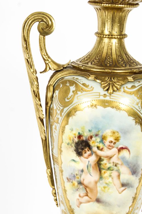 fig 4. A 19th-century French Sevres-style porcelain urn lamp painted with cherubs, featuring gilt bronze handles, foliage mounts, and an onyx base.