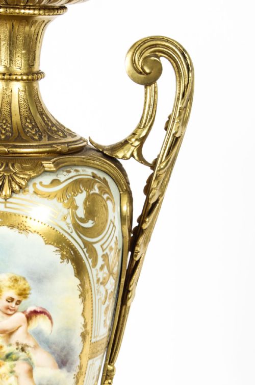 fig 5. A 19th-century French Sevres-style porcelain urn lamp painted with cherubs, featuring gilt bronze handles, foliage mounts, and an onyx base.