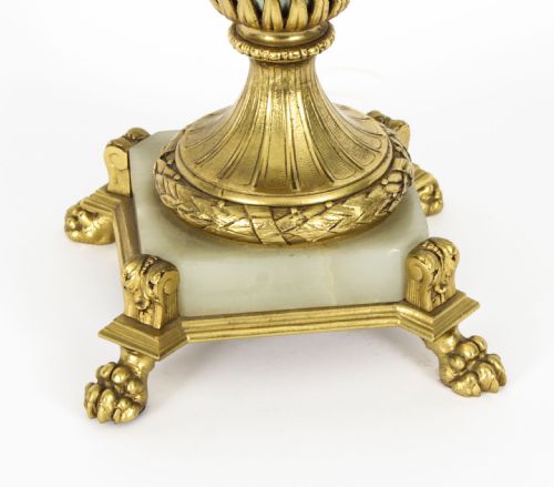 fig 6. A 19th-century French Sevres-style porcelain urn lamp painted with cherubs, featuring gilt bronze handles, foliage mounts, and an onyx base.