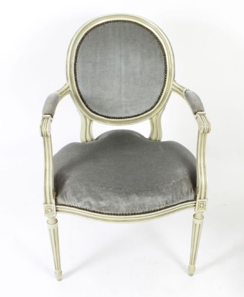 fig 1. A pair of early 20th-century French Louis XVI Revival armchairs with off-white painted frames, oval backs, and grey velvet upholstery.