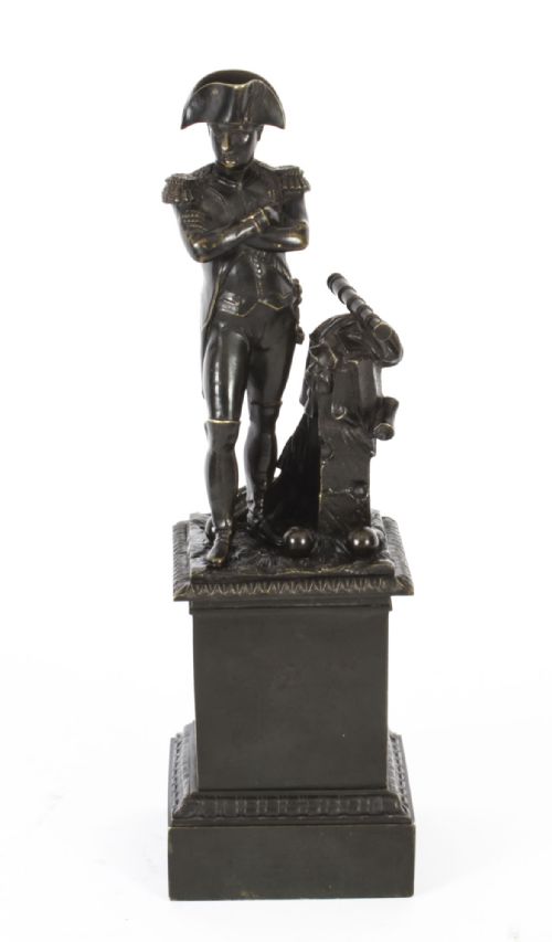 fig 1. A nineteenth-century dark patinated bronze statuette depicting Napoleon Bonaparte in military attire standing upon a rectangular bronze plinth.
