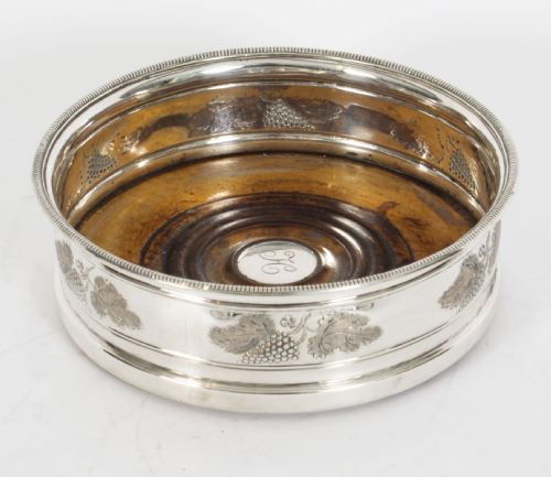 fig 1. A set of four circular Regency period Old Sheffield Plate wine coasters with turned wooden bases and foliage chased silver rims.