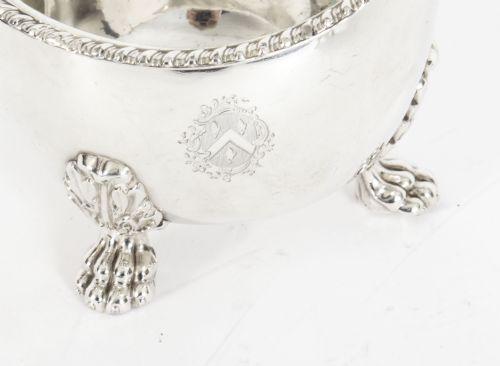fig 2. A pair of 19th-century silver-plated sauce boats featuring scroll handles, engraved crests, and claw feet against a white background.