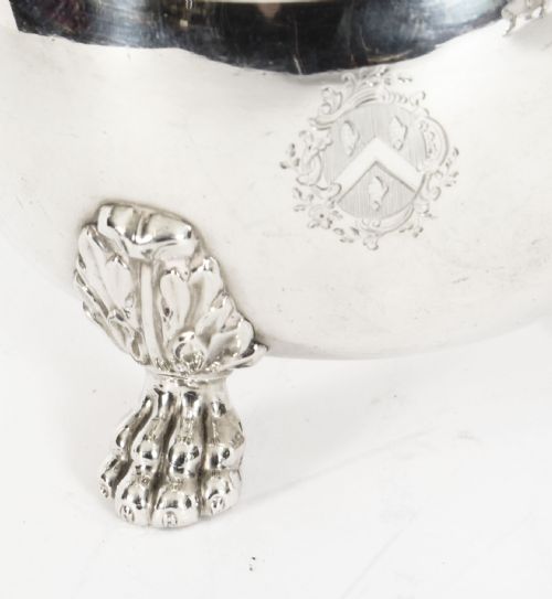 fig 3. A pair of 19th-century silver-plated sauce boats featuring scroll handles, engraved crests, and claw feet against a white background.