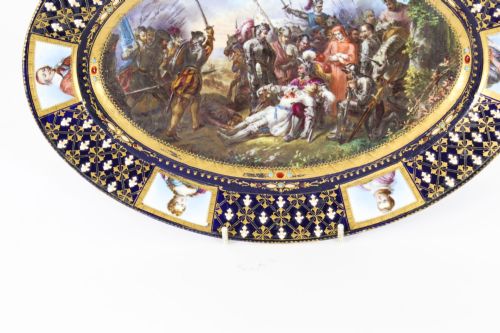 fig 5. An antique French oval porcelain dish featuring a central hand-painted historical battle scene surrounded by a cobalt blue border with gilt lattice work and portrait cartouches.