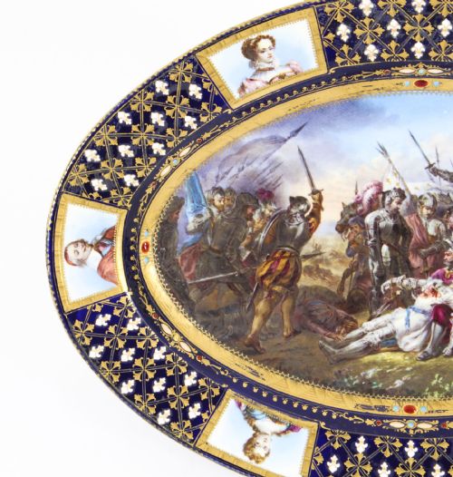 fig 6. An antique French oval porcelain dish featuring a central hand-painted historical battle scene surrounded by a cobalt blue border with gilt lattice work and portrait cartouches.