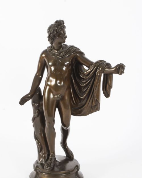 fig 1. A nineteenth-century dark brown bronze sculpture depicting the classical Greek god Apollo standing with draped cloth on a circular base.