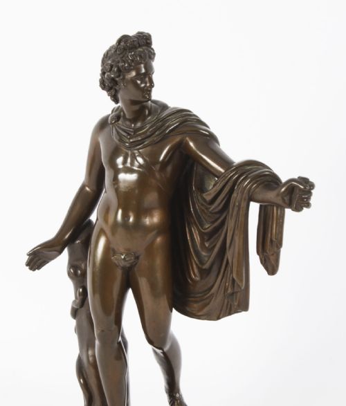 fig 4. A nineteenth-century dark brown bronze sculpture depicting the classical Greek god Apollo standing with draped cloth on a circular base.