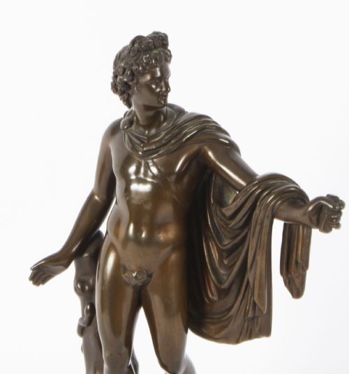 fig 6. A nineteenth-century dark brown bronze sculpture depicting the classical Greek god Apollo standing with draped cloth on a circular base.
