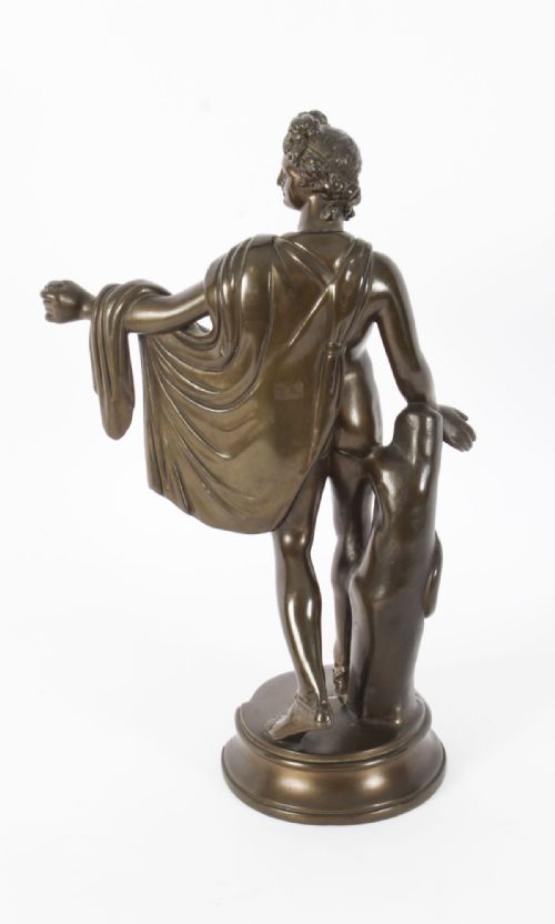 fig 7. A nineteenth-century dark brown bronze sculpture depicting the classical Greek god Apollo standing with draped cloth on a circular base.