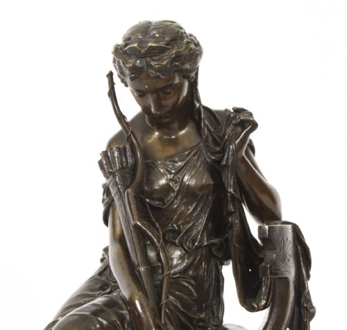 fig 1. A 19th-century dark patinated bronze sculpture depicting the classical goddess Diana seated on a chair with a bow and quiver, set upon an oval base.