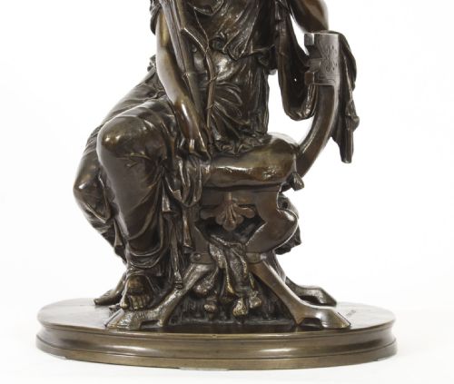 fig 2. A 19th-century dark patinated bronze sculpture depicting the classical goddess Diana seated on a chair with a bow and quiver, set upon an oval base.