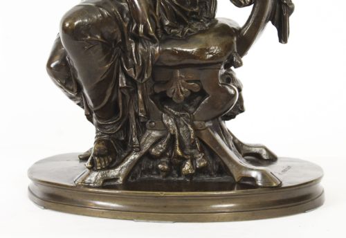 fig 3. A 19th-century dark patinated bronze sculpture depicting the classical goddess Diana seated on a chair with a bow and quiver, set upon an oval base.