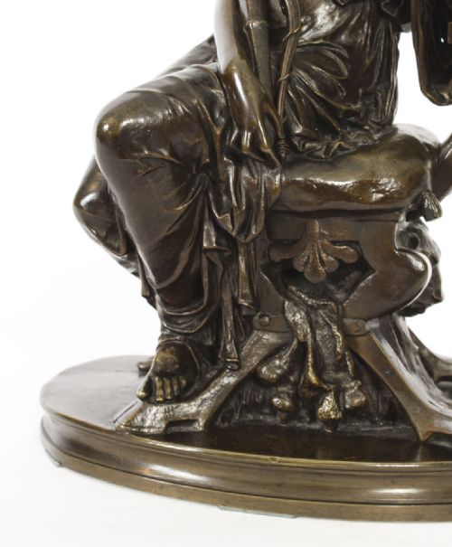 fig 4. A 19th-century dark patinated bronze sculpture depicting the classical goddess Diana seated on a chair with a bow and quiver, set upon an oval base.