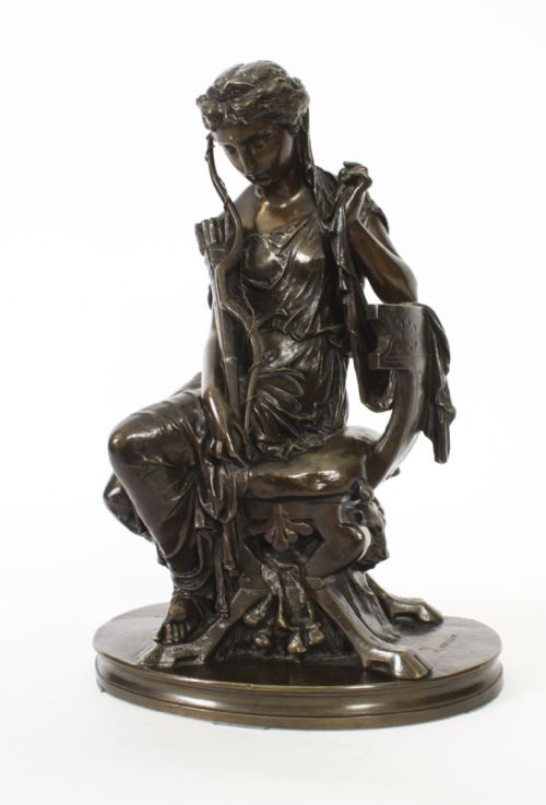 fig 5. A 19th-century dark patinated bronze sculpture depicting the classical goddess Diana seated on a chair with a bow and quiver, set upon an oval base.